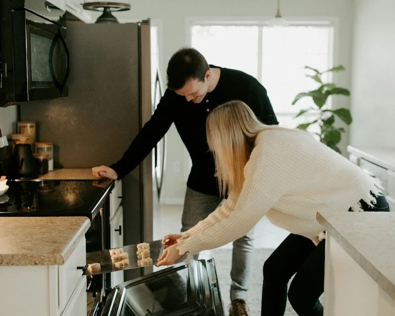 A man and a woman baking in a kitchen