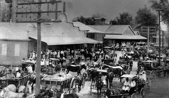 Saturday afternoon in front of the company stores and office buildings in Sugar Land. People from nearby farms came into town to shop and visit. The sign on the large refinery building reads “Cunningham Sugar operated by Imperial Sugar”.